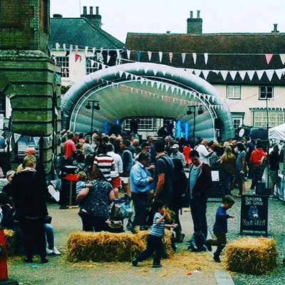 a crowd of people standing around in a market at Watt Cottage in Ipswich