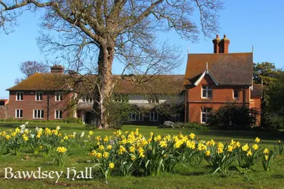 a house with yellow daffodils in front of it at Bawdsey Hall in Bawdsey