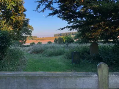 a view of a field with a wooden fence at Crown House Great Glemham in Saxmundham