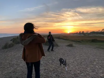 a man and a woman walking a dog on the beach at Crown House Great Glemham in Saxmundham
