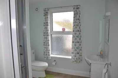a bathroom with a toilet and a sink and a window at Victoria Villa Guesthouse in Clacton-on-Sea