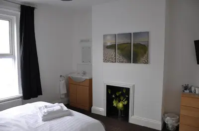 a bedroom with a bed and a fireplace at Victoria Villa Guesthouse in Clacton-on-Sea