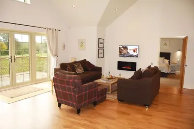 a living room with two couches and a tv at Ransom Lodge in Chappel