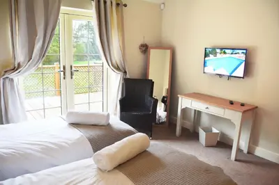 a bedroom with a bed and a television and a chair at Ransom Lodge in Chappel