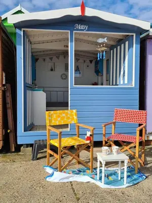 two chairs and a table in front of a house at Brook Lodge in Colchester