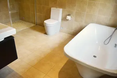a bathroom with a toilet and a tub and a sink at Brook Lodge in Colchester