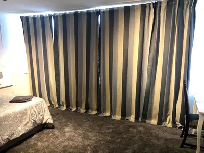 a bedroom with a bed and a window with curtains at AC Lounge 125 in Rochford