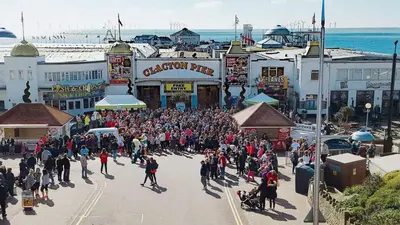 a large crowd of people walking down a street at The Langtry Hotel in Clacton-on-Sea