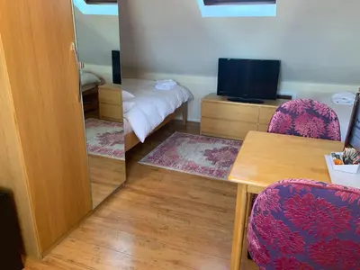 a room with a mirror and a table and a tv at Parkview Guesthouse in Cambridge