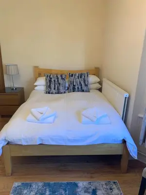 a bedroom with a large bed with blue sheets and pillows at Parkview Guesthouse in Cambridge