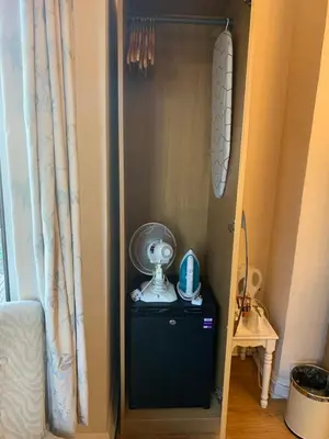 a room with a fan on top of a dresser at Parkview Guesthouse in Cambridge