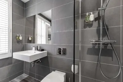 a bathroom with a toilet and a sink and a shower at The Regent Aparthotel in Cambridge
