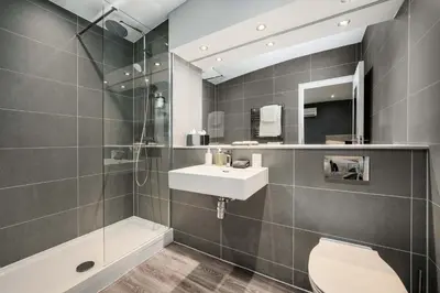 a bathroom with a sink and a toilet and a shower at The Regent Aparthotel in Cambridge