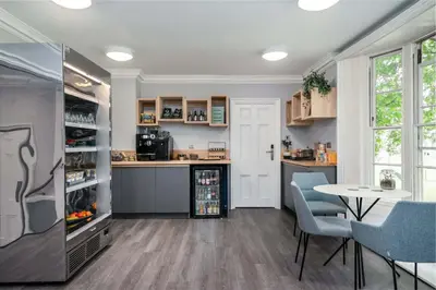 a kitchen with a table and chairs and a refrigerator at The Regent Aparthotel in Cambridge