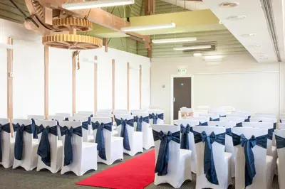 a room with rows of chairs with blue bows at Holiday Inn Ipswich by IHG in Ipswich