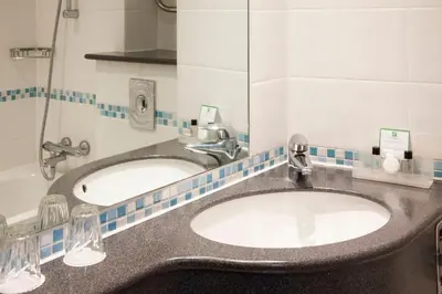 a bathroom with two sinks and a mirror at Holiday Inn Ipswich by IHG in Ipswich