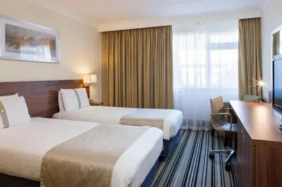 a hotel room with two beds and a desk at Holiday Inn Ipswich by IHG in Ipswich