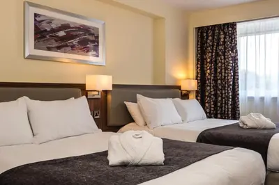 a hotel room with two beds and a window at Holiday Inn Colchester by IHG in Colchester