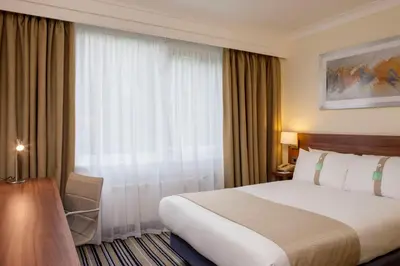 a hotel room with a large bed and a window at Holiday Inn Colchester by IHG in Colchester