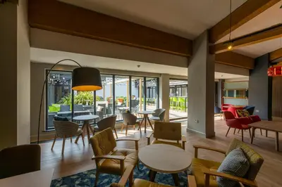 a lobby with tables and chairs and a patio at Holiday Inn Cambridge by IHG in Cambridge