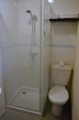 a bathroom with a shower with a toilet and a shower at Ely Guest House in Ely