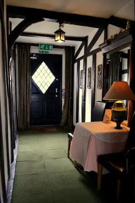 a room with a table and a door with a lamp at Ely Guest House in Ely