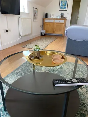 a glass coffee table in a living room with a remote control at The Cherry Tree in Woodbridge
