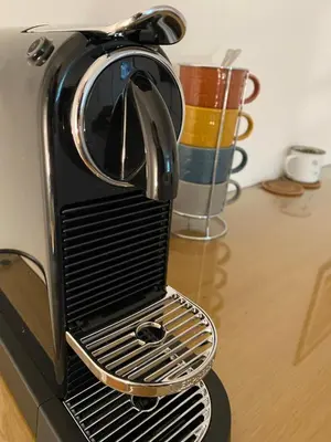 a toaster oven sitting on a table with a cup at The Cherry Tree in Woodbridge