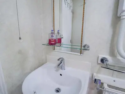 a bathroom with a white sink and a mirror at The Lodge in Attleborough