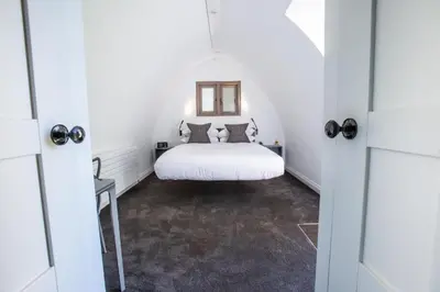 a bedroom with a white bed in a white room at Tuddenham Mill Luxury Hotel in Tuddenham