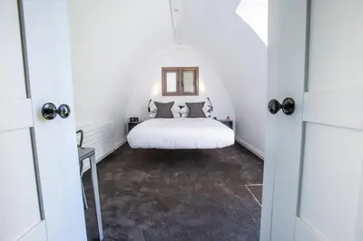 a bedroom with a white bed in a white room at Tuddenham Mill Luxury Hotel in Tuddenham