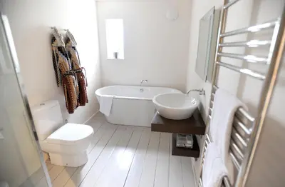 a bathroom with a tub and a toilet and a sink at Tuddenham Mill Luxury Hotel in Tuddenham