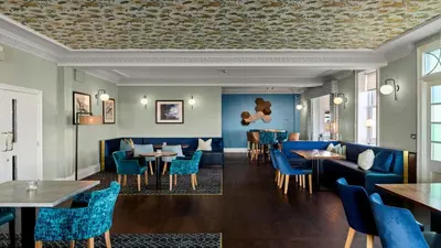 a restaurant with blue chairs and tables at Kingscliff, Holland on Sea in Clacton-on-Sea