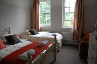 a bedroom with two beds and two windows at The Castle Bar ROOM ONLY in Cambridge