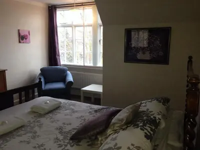 a bedroom with a bed and a chair and a window at The Castle Bar ROOM ONLY in Cambridge