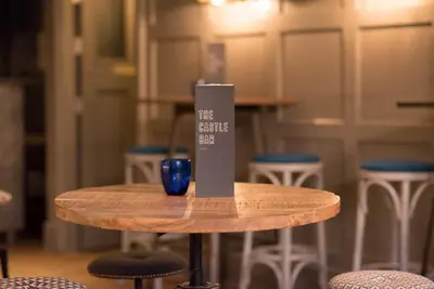 a table with a blue glass sitting on top of it at The Castle Bar ROOM ONLY in Cambridge