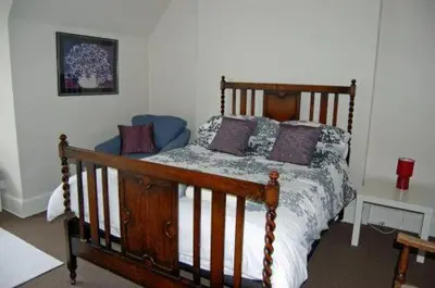 a bedroom with a wooden bed with pillows on it at The Castle Bar ROOM ONLY in Cambridge