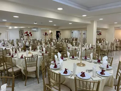 a banquet hall with white tables and chairs at Zaheer's Hotel in Baldock