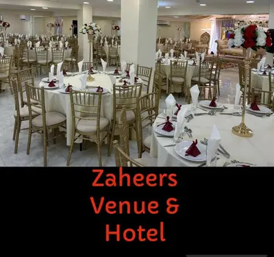 a dining room with white tables and chairs at Zaheer's Hotel in Baldock