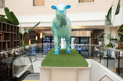a statue of a cow on a platform in a store at Hilton Cambridge City Centre in Cambridge
