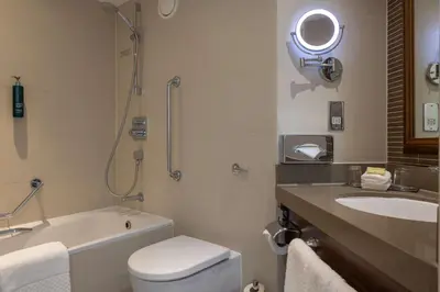 a bathroom with a sink and a toilet and a bath tub at Hilton Cambridge City Centre in Cambridge
