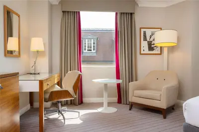 a hotel room with a desk and a chair at Hilton Cambridge City Centre in Cambridge