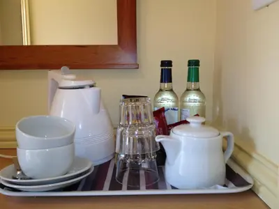 a kitchen shelf with dishes and bottles of wine at The Olde Windmill Inn in Great Cressingham