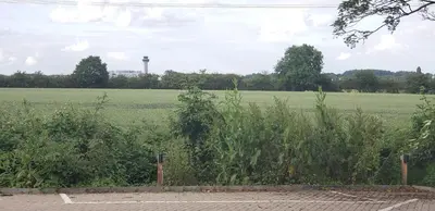 a field of grass with a water tower in the distance at Stansted Airport Lodge in Takeley