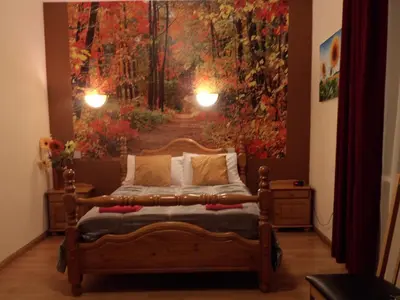 a bedroom with a bed with a large painting on the wall at Stansted Airport Lodge in Takeley