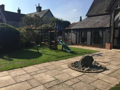 a backyard with a playground with a slide at South Barn in Stanningfield
