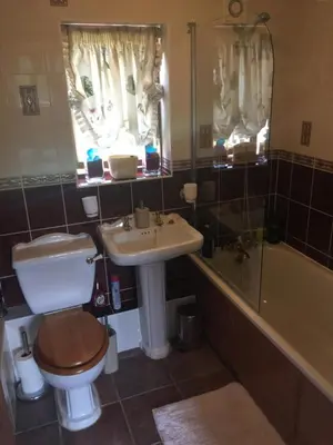 a bathroom with a toilet and a sink and a tub at South Barn in Stanningfield