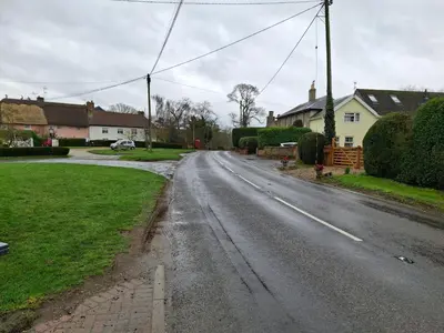 an empty road in a residential neighborhood with houses at South Barn in Stanningfield