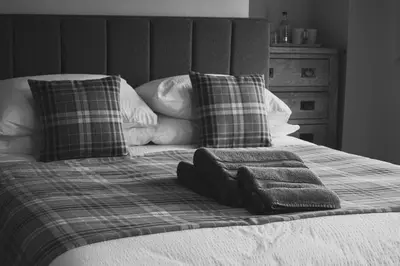 a bed with two pillows and two towels on it at The Kings Head in New Buckenham