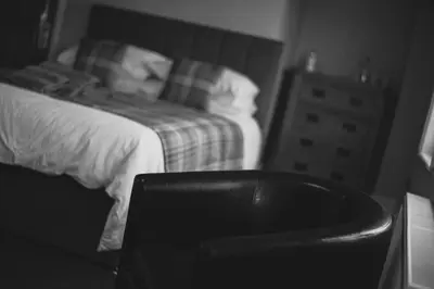 a black and white photo of a bedroom with a bed at The Kings Head in New Buckenham